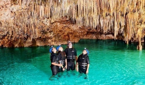 People standing in water in a cave