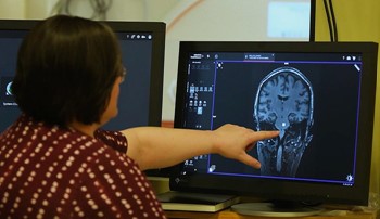 A researcher points at a brain scan in the Auburn University Neuroimaging Center