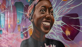 Mural featuring a smiling student surrounded by candles
