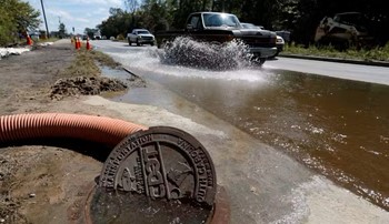 Water pouring out of manhole cover during flood