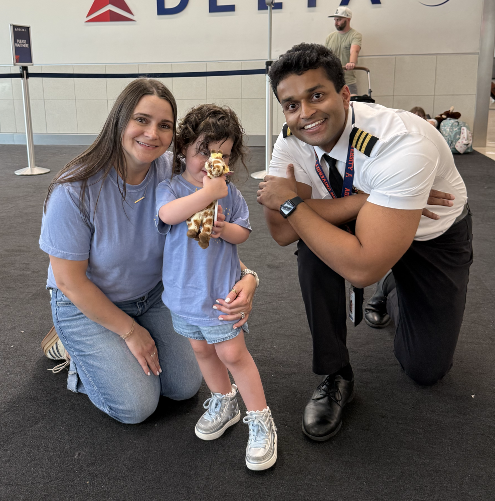 Push Saha posing for a photo with a child and her mother at the airport