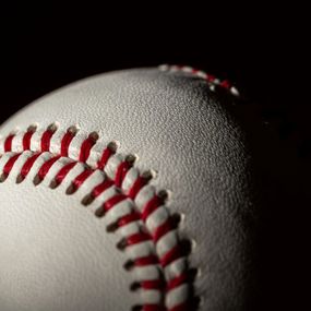 Closeup of a baseball half in shadow
