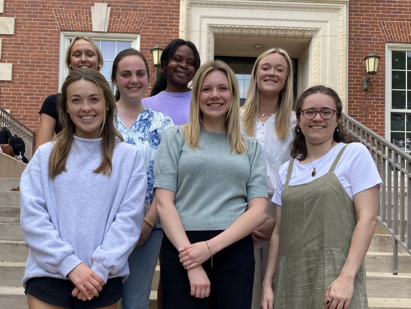 Group of students standing in front of a brick building