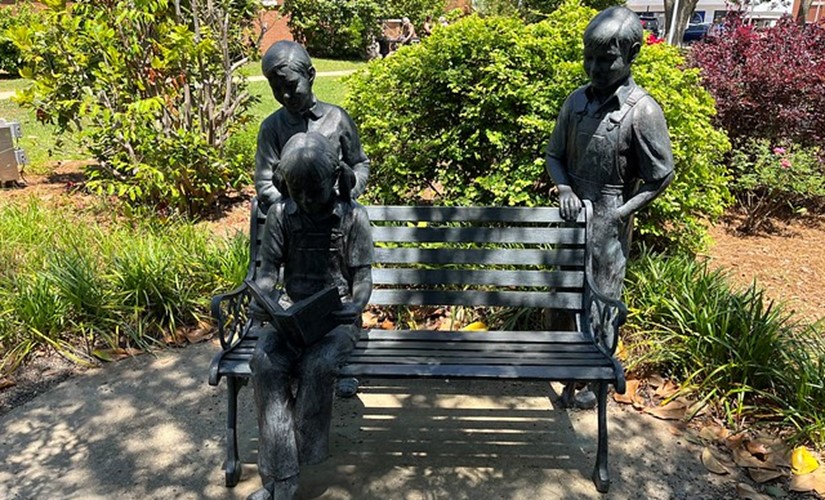 An iron statue showing Scout and Jem Finch with friend Dill Harris outside the Monroe County Courthouse