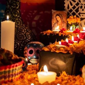 A traditional Day of the Dead ofrenda with candles and colorful skulls