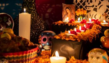 A traditional Day of the Dead ofrenda with candles and colorful skulls