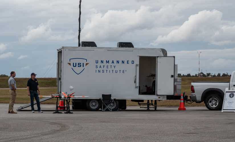 truck pulling a trailer that carries drones