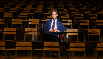 Elijah Gaddis sitting at a desk inside an Auburn University lecture hall