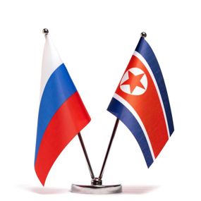 Russia and North Korea flags sitting beside each other on a table
