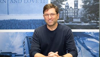 Andy Young sitting at desk in a broadcast center