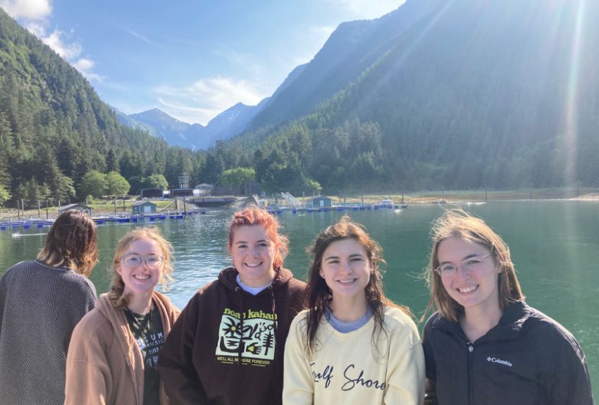 Group of students standing by a lake with a mountain in the background