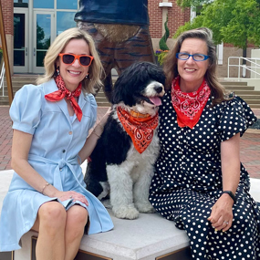 Kay Whaley and Kathryn Hamrick posing for a photo with Sydney the dog on Auburn's campus