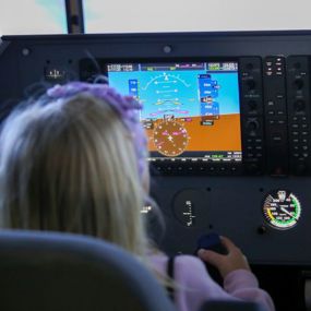 Child sitting in a plane simulator