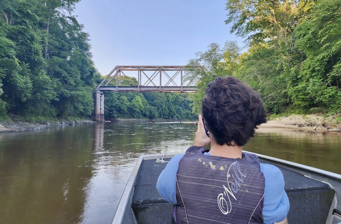 Oyola kayaks on the Pea River during summer of Living Democracy.