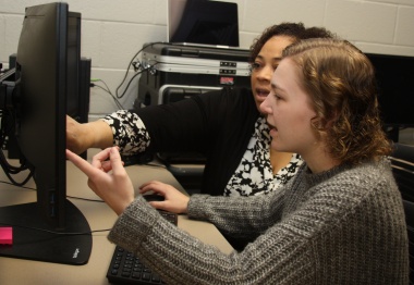 Student and teacher working on a computer