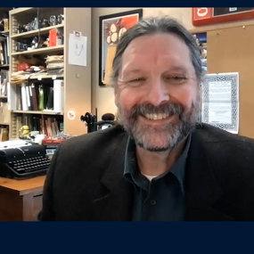 Professor Ed Youngblood smiles while recording a podcast