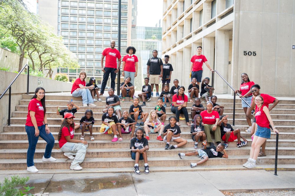 DeBose and other NYCOBA NOMA members posing for a photo with children in the Project Pipeline educational program