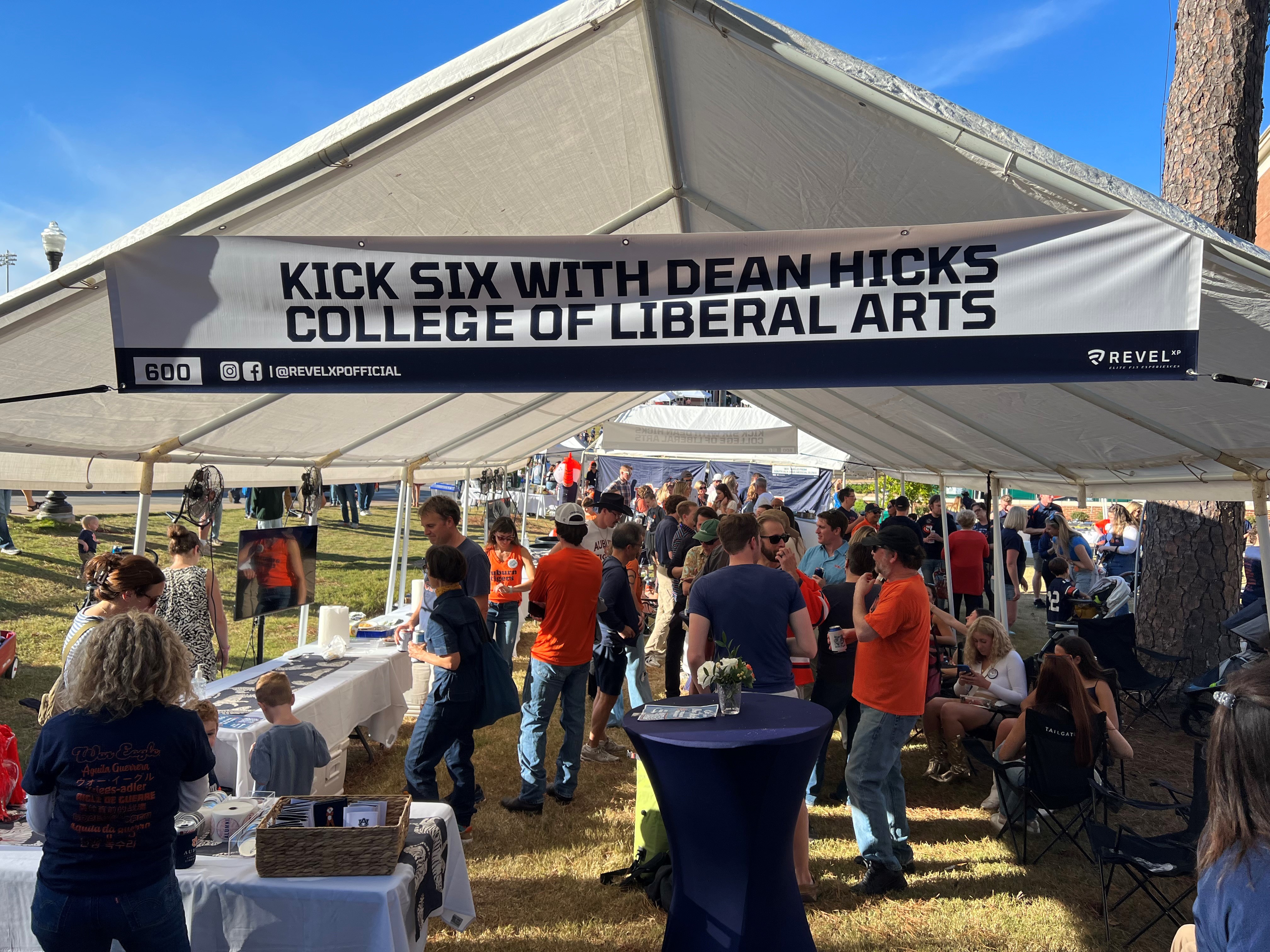 lively scene of Dean Hicks at the tailgate event, connecting with students and promoting engagement