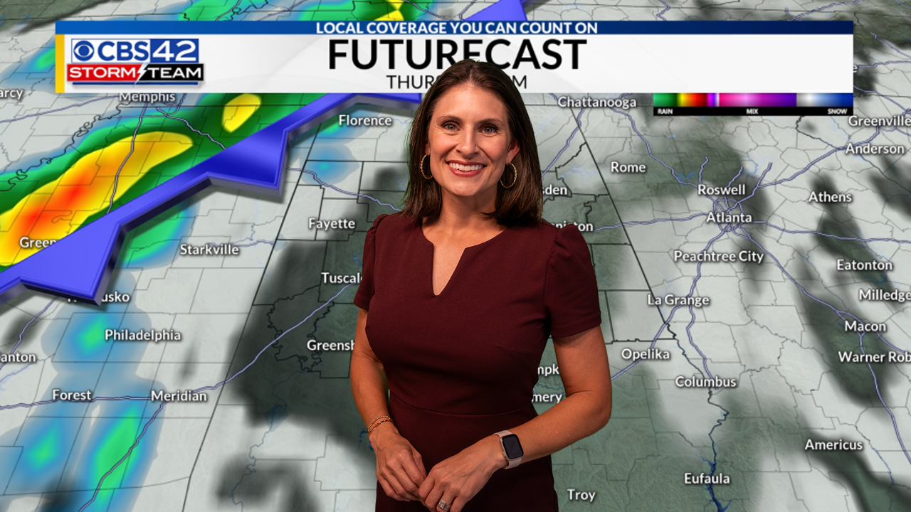 Ashley Gann smiling for photo in front of weather forecast map