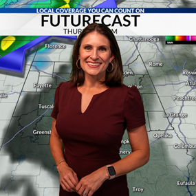 Ashley Gann smiling for photo in front of weather forecast map