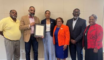 Members of the John Lewis family present Ernest Gibson with a framed copy of his poem "This Land"