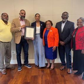 Members of the John Lewis family present Ernest Gibson with a framed copy of his poem "This Land"