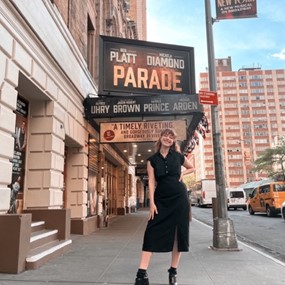 Ashley Digiovanni standing under Broadway theatre sign