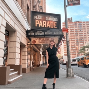 Ashley Digiovanni standing under Broadway theatre sign