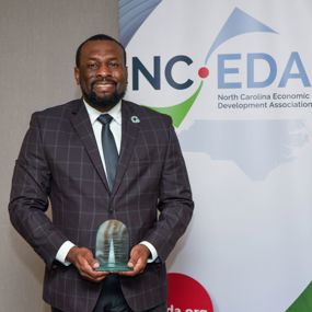 Marvin Price holding the NCEDA Deal of the Year Award