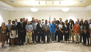 large group of people standing together in a conference room
