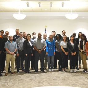 large group of people standing together in a conference room