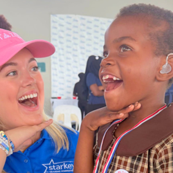 caylyn turner poses with young girl wearing hearing aid