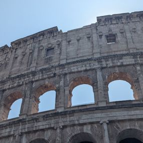The Colosseum in Rome rising up into a blue sky