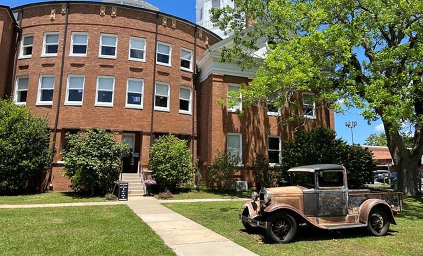 A historic truck parked on the lawn of the Monroe County Courthouse