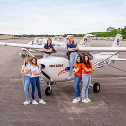 The War Eagle Women teams competing in ARC pose with an Auburn University plane