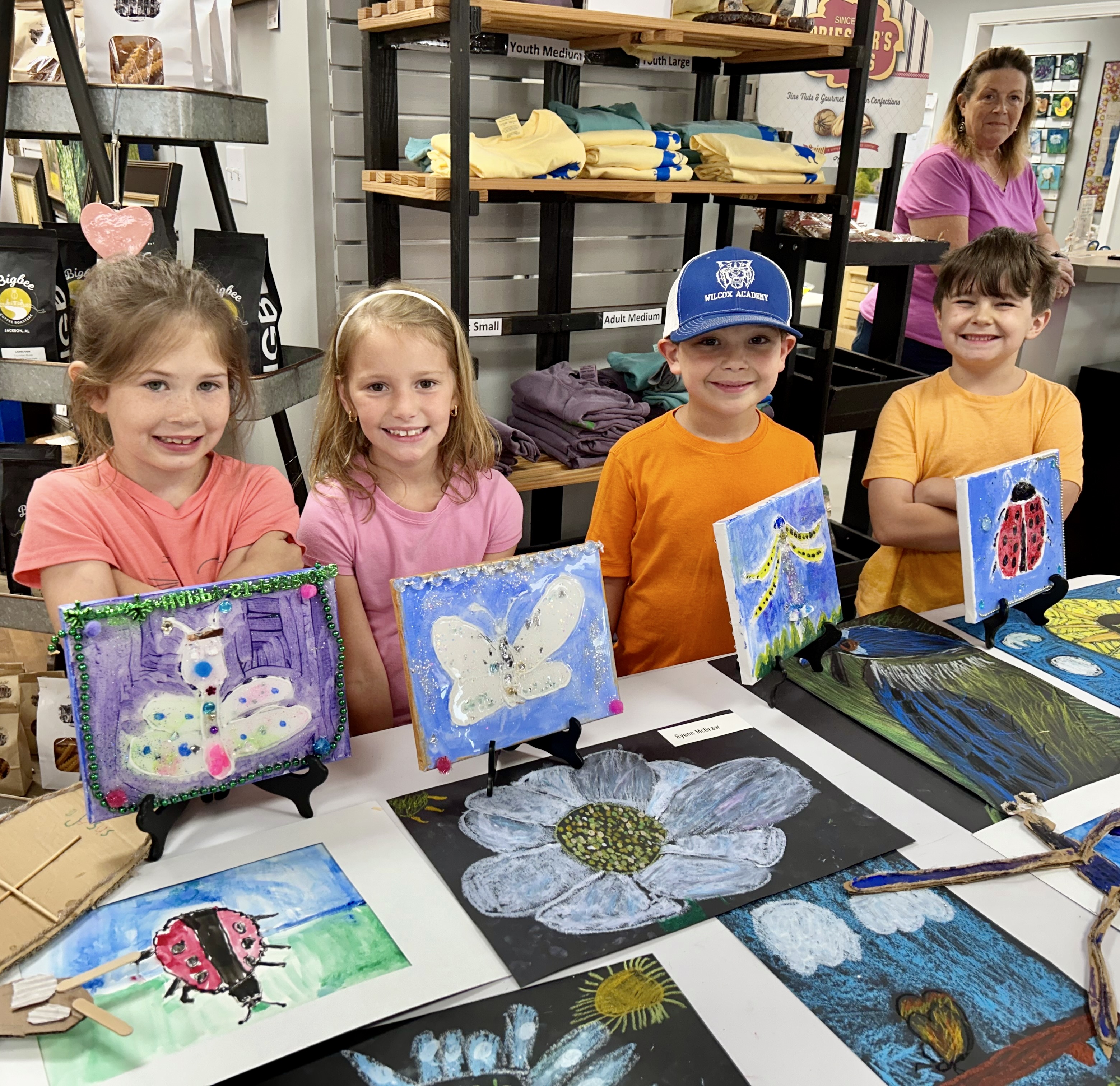 Pictured from left to right, Sutton McGraw, Ryann McGraw, Christopher Jordan, and Luke Hunter showcase the art they created throughout the week at the end during the end of camp week art exhibit.