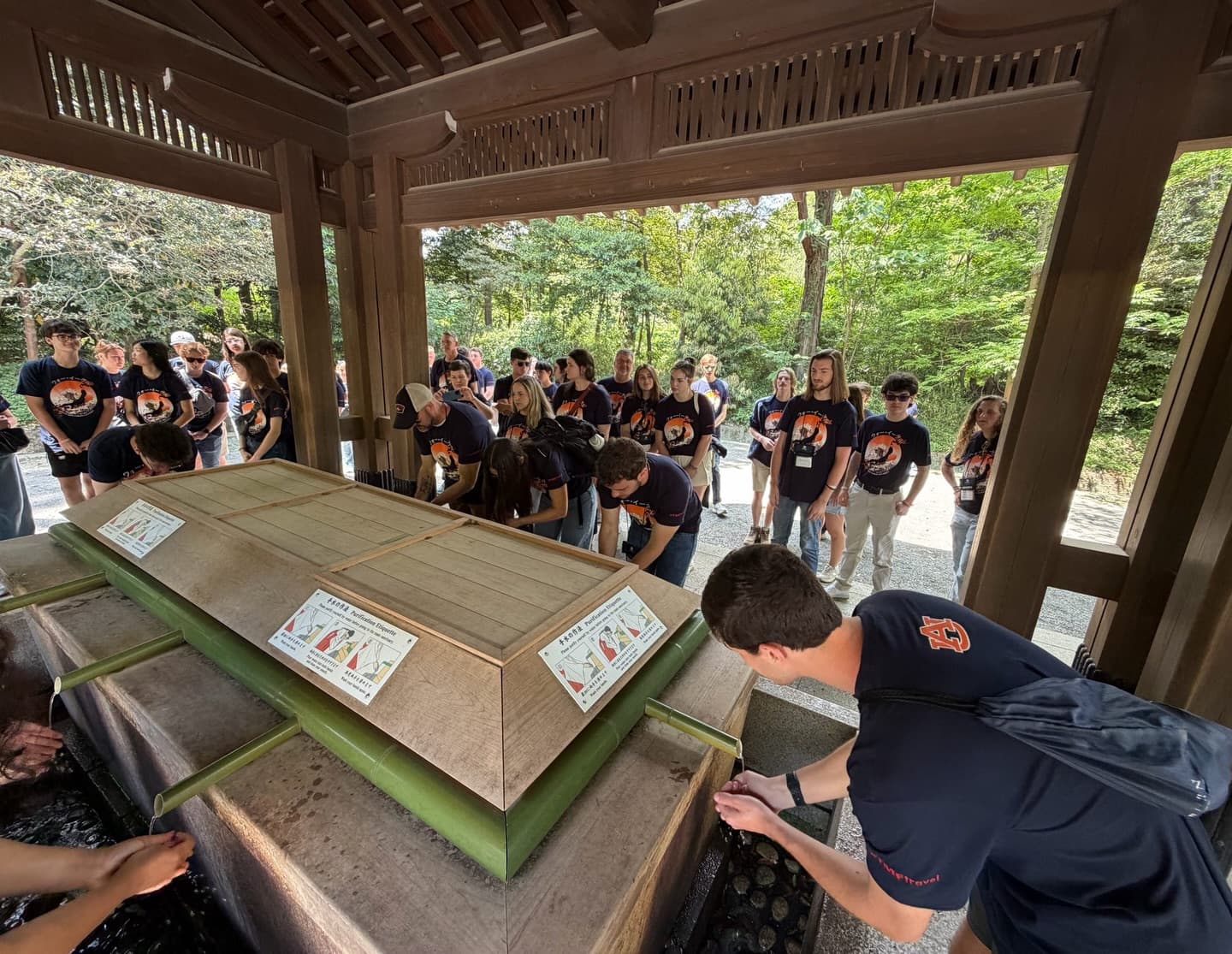 Auburn students washing their hands at a bamboo purification station