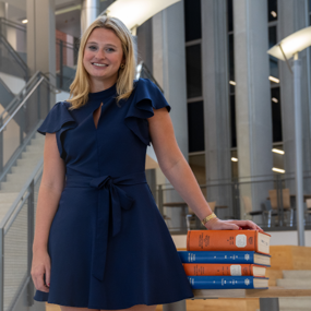 Isabella Dee with books in the RBD Library at Auburn