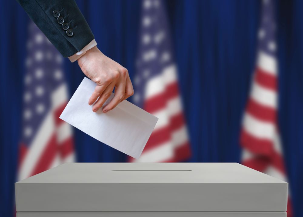 A citizen casting a vote into a polling box during an election.
