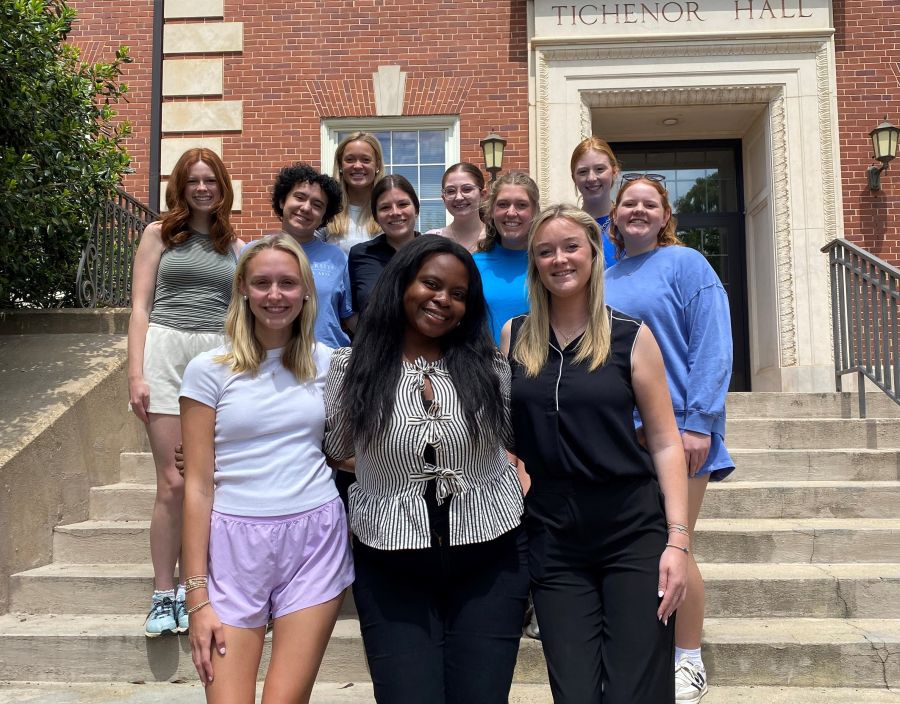 Group of students standing in front of a brick building