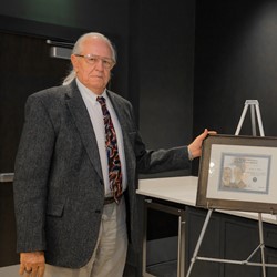 James Witte stands with a framed Wright Brothers Master Pilot Award