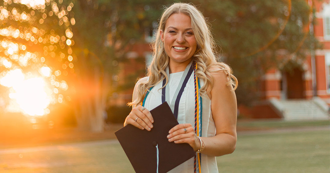 Katie Jett posing with graduation cap outside Samford Hall