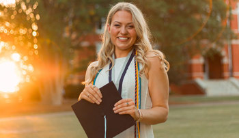 Katie Jett posing with graduation cap outside Samford Hall