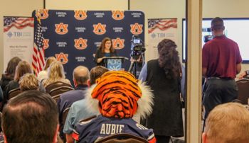 Aubie sitting in the audience of the Opelika TBI center ribbon cutting ceremony