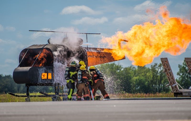 Firefighters hose down the burning shell of a helicopter