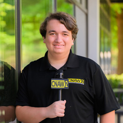 Colin Scroggins holding a CNAW2 News microphone