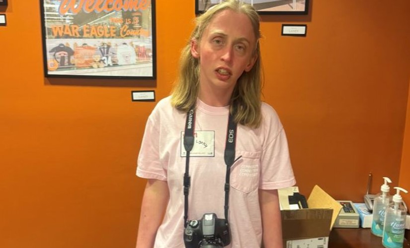 Braveheart artist Laney standing beside photos of Toomer's Corner