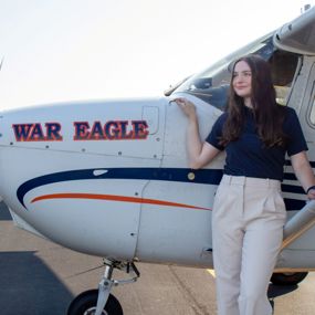 Jessica McGrath standing beside an Auburn airplane