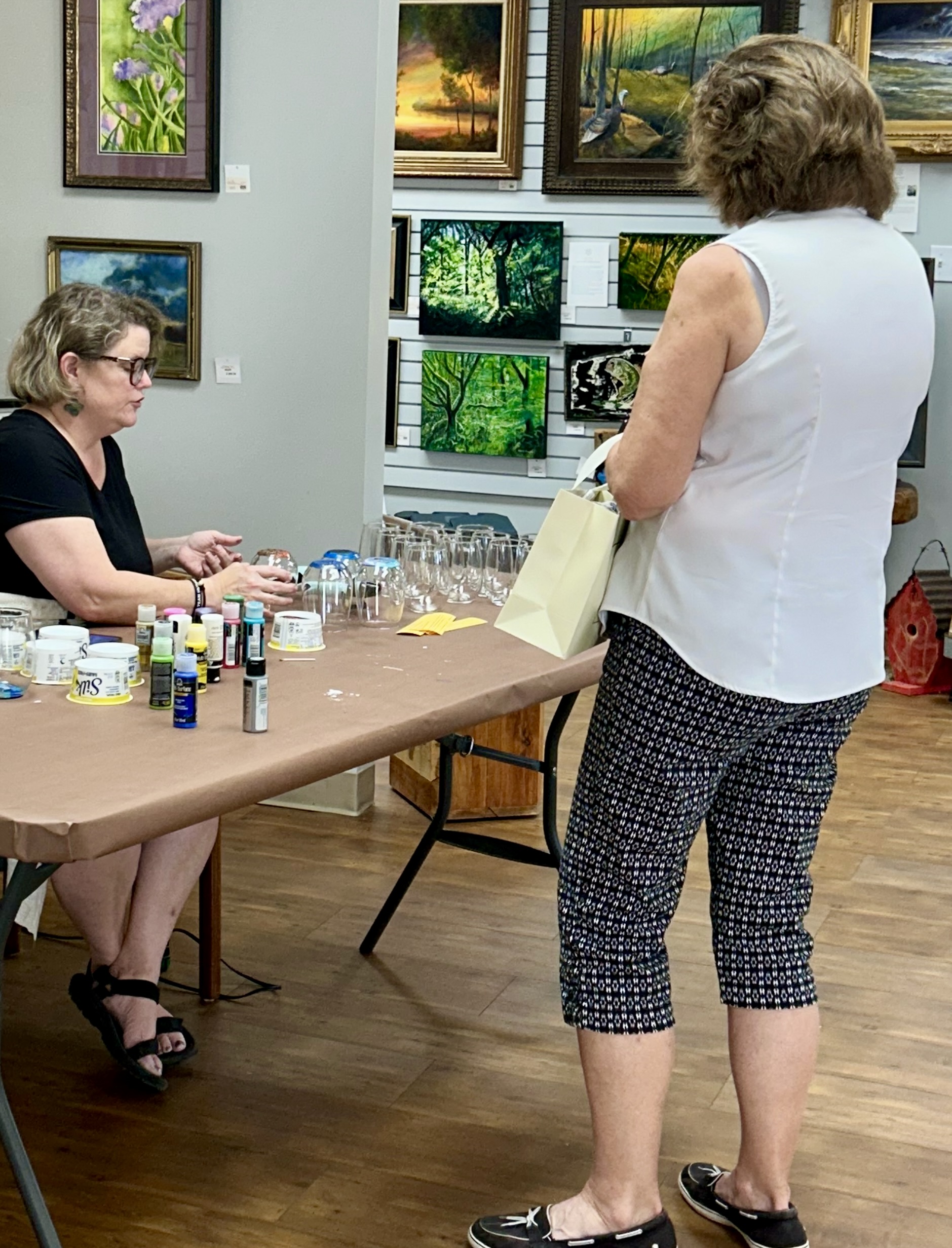 Kristin Law, seated, demonstrates the class painting station offered at Black Belt Treasures Cultural Arts Center.