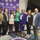 Group of faculty standing in front of International Women's Day sign